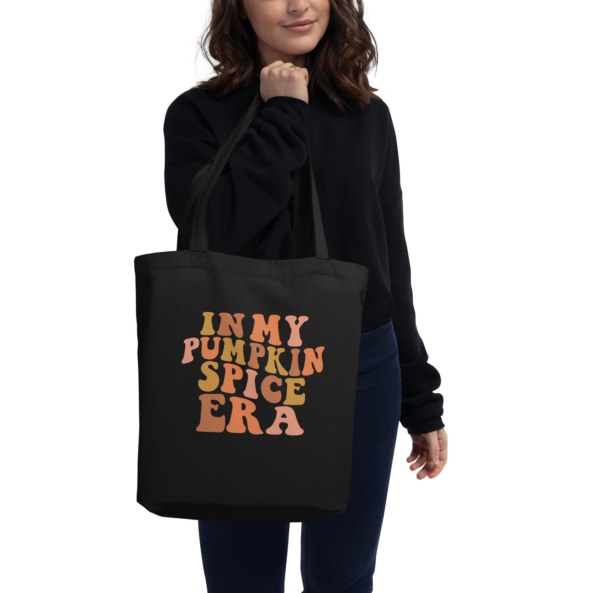 Woman holding Black cotton tote bag that says "In My Pumpkin Spice Era"
