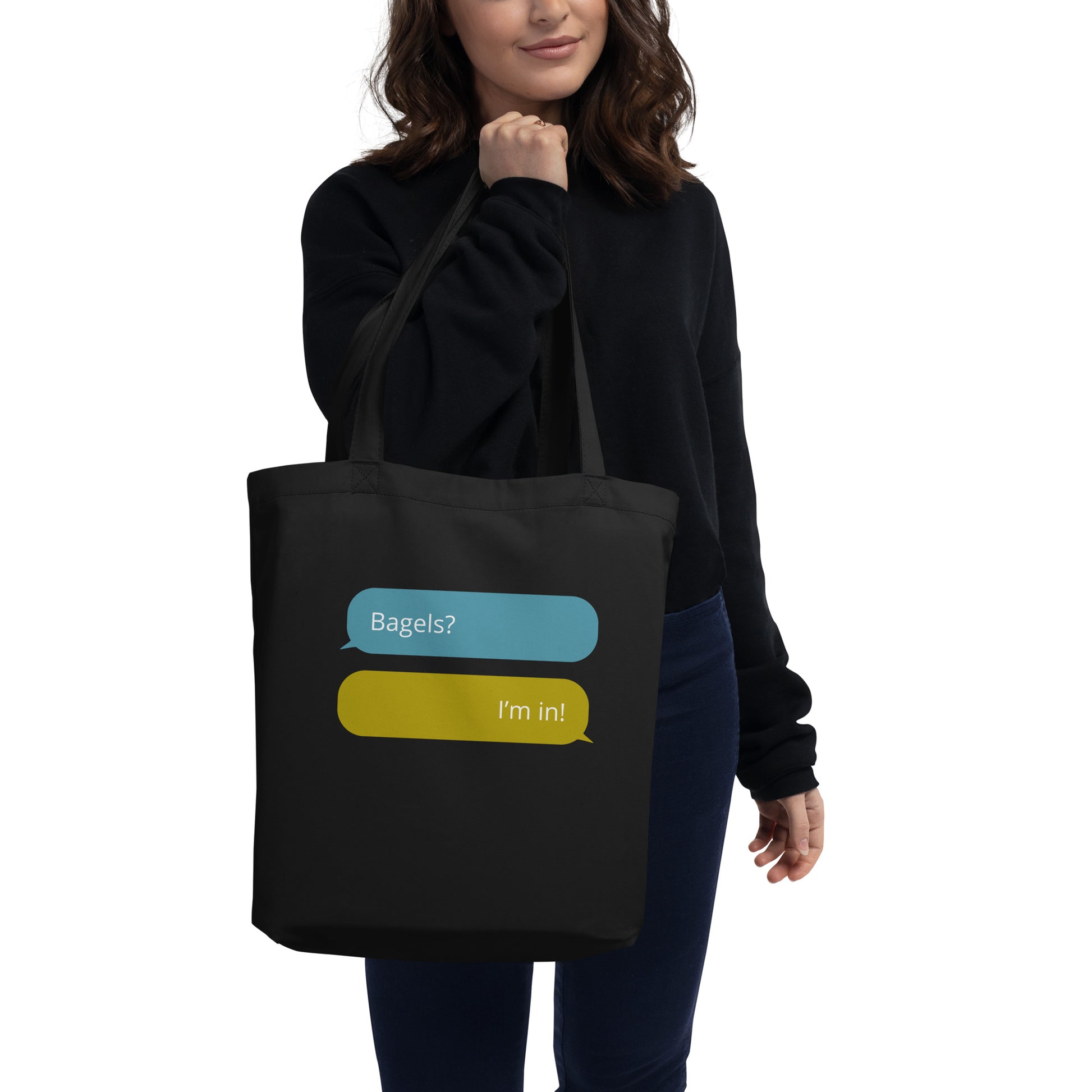 Woman holding a black cotton tote bagel with text message graphic that says Bages?, I'm in! 