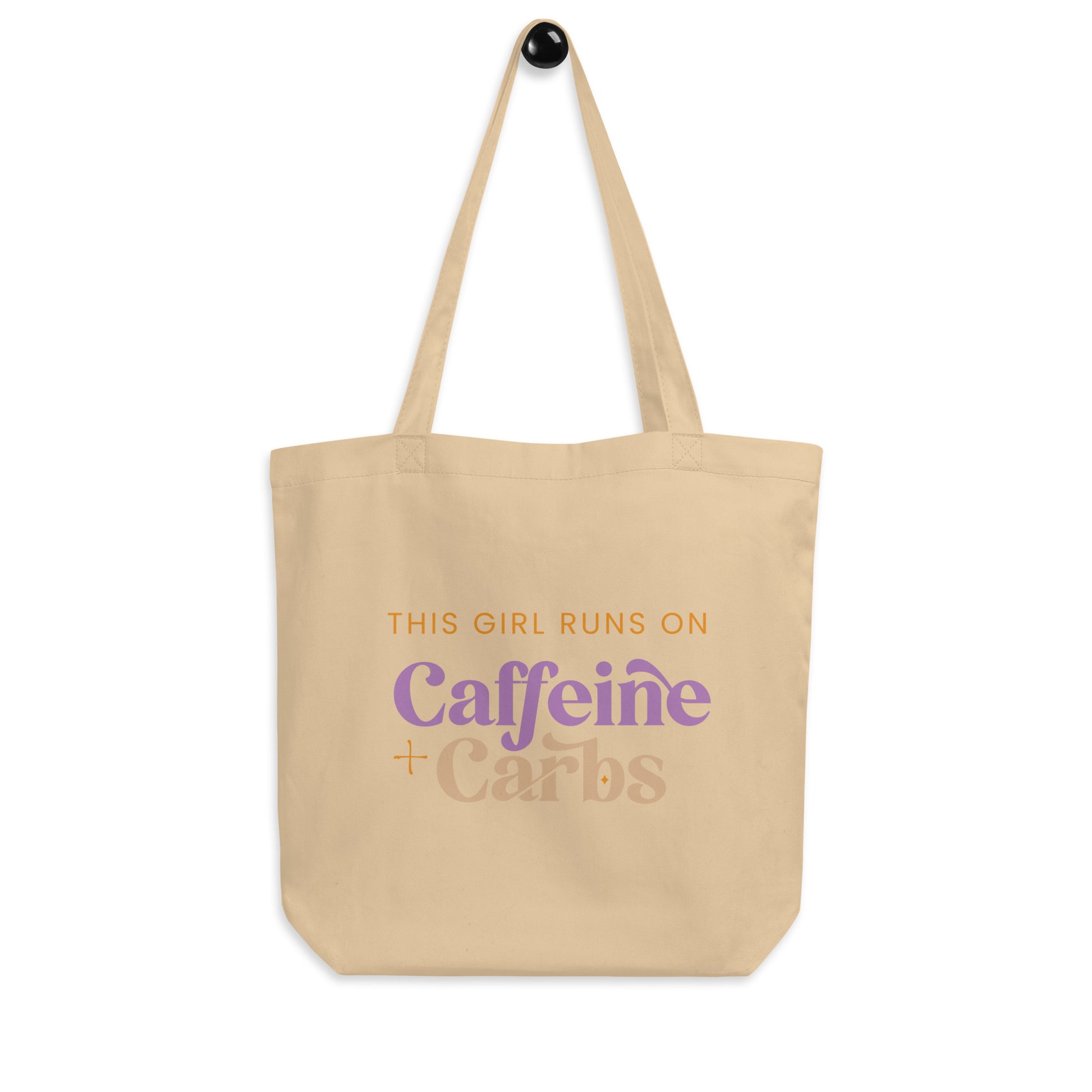 Tan cotton tote bag that says "This girl runs on caffeine + carbs"