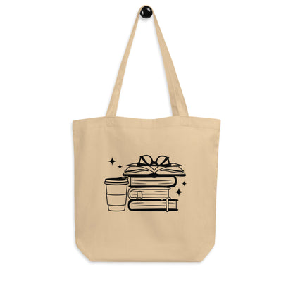 Tan tote bag with stack of books, glasses and to go coffee cup