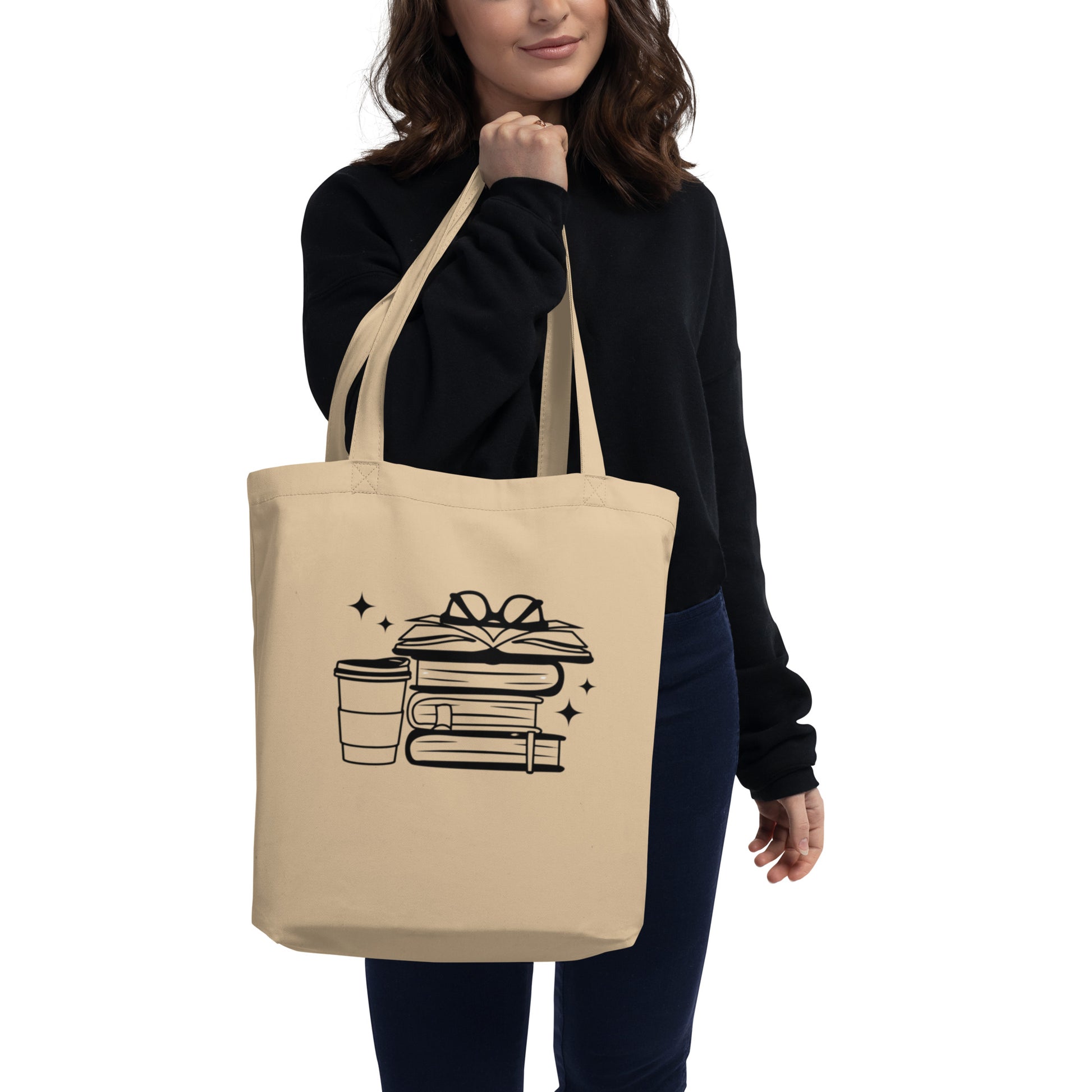 woman holding tan tote bag with stack of books graphic